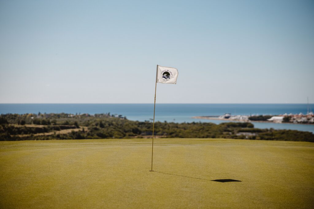 Beautiful golf course with ocean view in Santo Domingo, Dominican Republic, featuring a white flag.